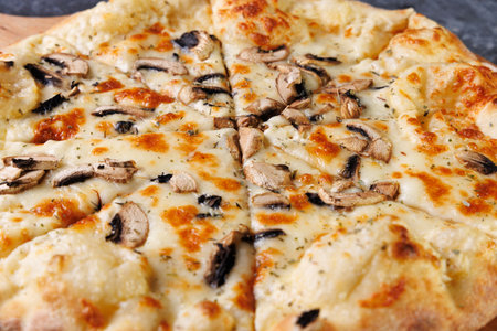 Gourmet Mushroom Cheese Pizza On Circular Wooden Board, Freshly Baked and Ready to Serveの写真素材