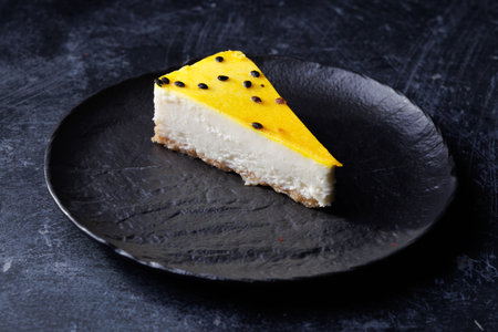 Creamy Cheesecake Slice With Mango Glaze On Black Plate, Elegant Dessert Shotの写真素材