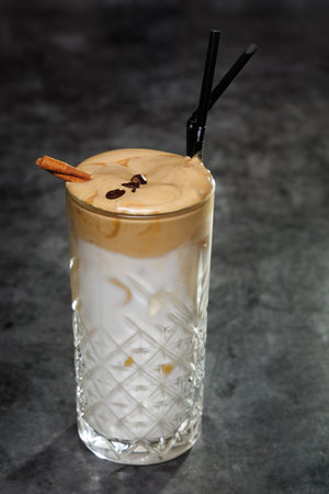 Creamy Iced Latte With Cinnamon Stick And Coffee Beans In Crystal Glassの写真素材