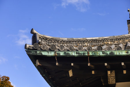A historic Japanese temple complex featuring dark tiled roofs, white walls, and wooden shutters. Bright sky, tranquil grounds, and traditional architecture evoke heritage, culture, and peaceful travel in a cultural site.の写真素材