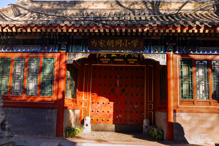 Vibrant temple entrance featuring a richly painted arch, gold trim, and stone guardian lions. Bright colors and intricate carvings reflect traditional Chinese architecture and cultural heritage.の写真素材
