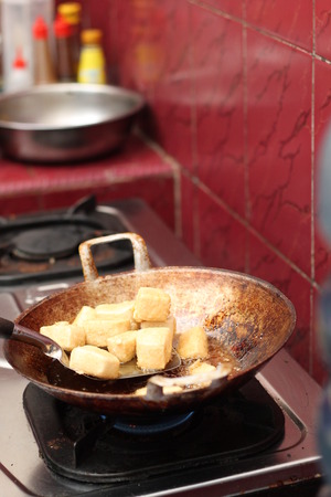 frying tofu in a frying panの写真素材