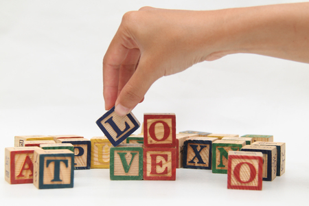Hand holding the letter, which forms the word "love"の写真素材