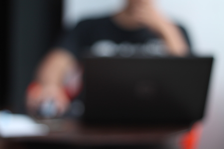 in front of the laptop (blur image)の写真素材