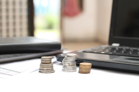 coins on the table, with laptops and financial reports.の写真素材