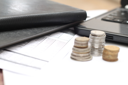 coins on the table, with laptops and financial reports.の写真素材