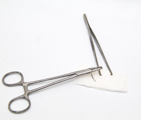 a surgery needle (straight 1/2 circle), needle holder and bandageの写真素材