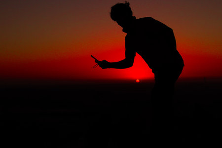 Man use mobile sunset photography