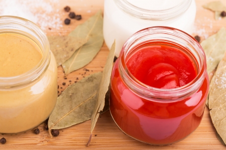 Ketchup and other sauces, spices on the cutting boardの写真素材