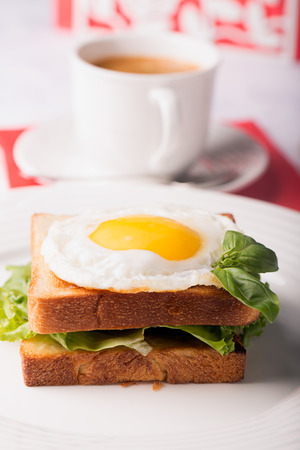 Breakfast: fried egg on the white bread and coffeeの写真素材