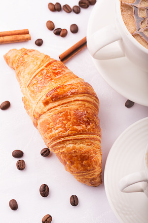 Croissant, vanilla and coffee beans on the tableの写真素材