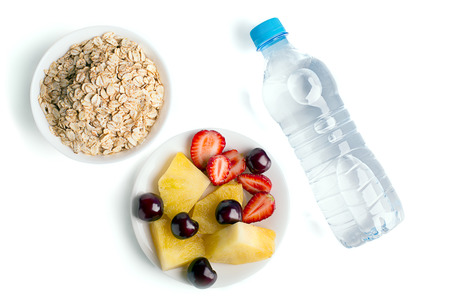 Healthy eating: muesli, berries, pineapple and bottle of waterの写真素材