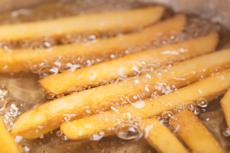 French fries in hot fat (close up shot)の写真素材