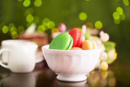 Colorful macaroons in the white bowl on a tableの写真素材