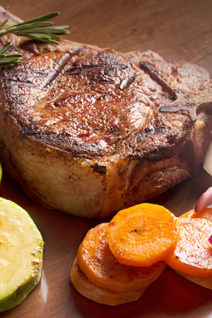 Grilled meat with vegetables and rosemary on the tableの写真素材