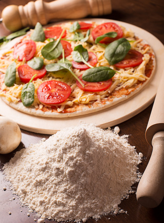 Raw Italian pizza with sausages and mushroomsの写真素材