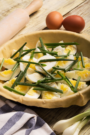 Rustic pie with eggs and onion on the wooden backgroundの写真素材