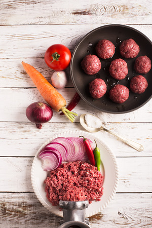 Meatballs on the pan and vegetables on the wooden tableの写真素材