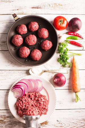 Meatballs on the pan and vegetables on the wooden tableの写真素材