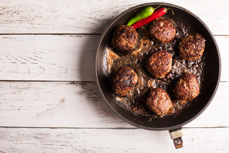 Fried meatballs on the pan with chili pepperの写真素材