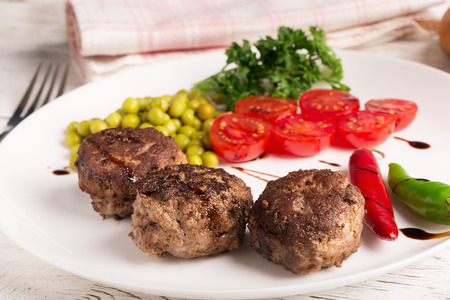Fried cutlets on the plate and wine on the wooden tableの写真素材