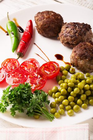 Fried meatballs on the plate and wine on the wooden tableの写真素材