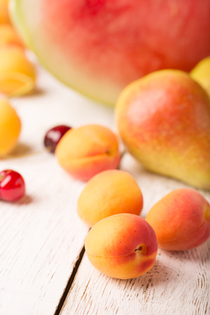 Tasty apricot and other fruits on a wooden tableの写真素材
