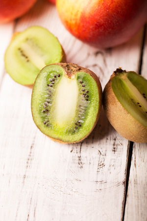 Sliced kiwi and other fruits on a wooden tableの写真素材