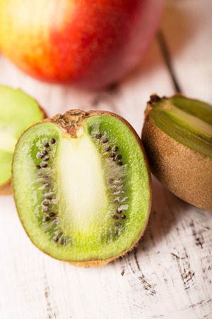 Sliced kiwi and other fruits on a wooden tableの写真素材