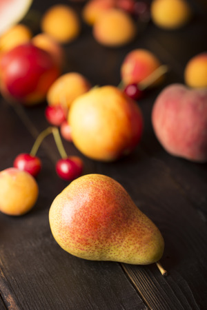 Tasty pears and other fruits on a wooden tableの写真素材