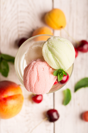 Tasty ice cream with cherry and fruitsの写真素材