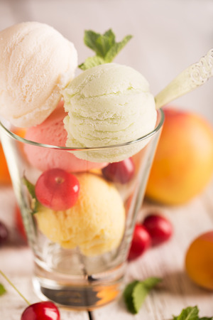 Tasty ice cream with cherry and fruitsの写真素材