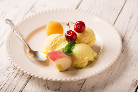 Tasty ice cream with cherry and fruitsの写真素材