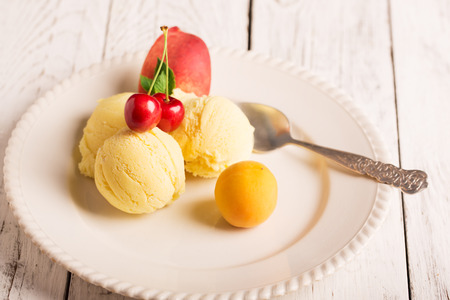 Tasty ice cream with cherry and fruitsの写真素材
