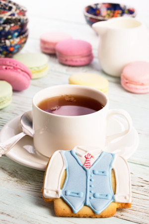 Cup of tea, cookies and macaroons on white wooden tableの写真素材