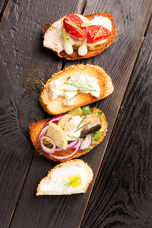 Tasty tapas with cheese and onion and fish on crusty breadの写真素材