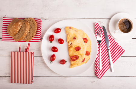 Omelette with tomatoes and cereal bead on the tableの写真素材