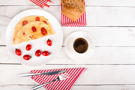 Omelette with tomatoes and cereal bead on the tableの写真素材