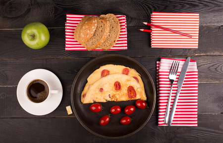 Omelette with tomatoes and cereal bead on the tableの写真素材