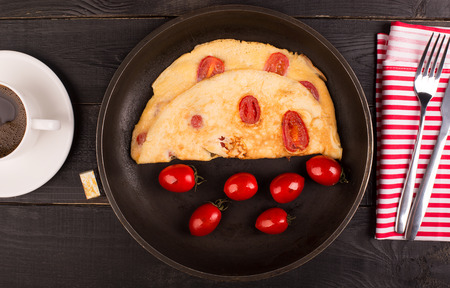 Omelette with tomatoes and cereal bead on the tableの写真素材
