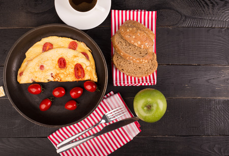 Omelette with tomatoes and cereal bead on the tableの写真素材