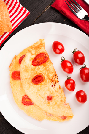 Omelette with tomatoes aon the white plateの写真素材