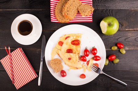 Omelette with tomatoes and cereal bead on the tableの写真素材