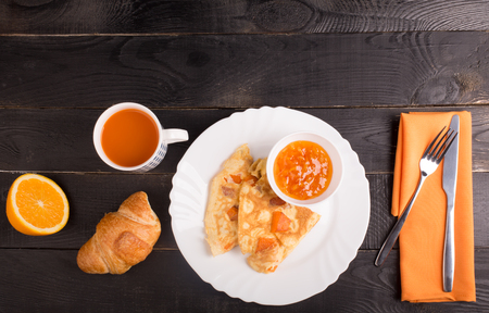 Omelette with pumpkin, carrot juice and croissant on the tableの写真素材