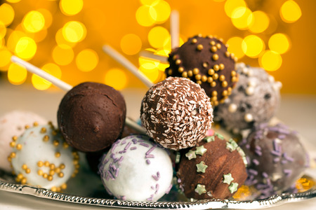 Colorful cake pops on the blurred yellow bokeh backgroundの写真素材