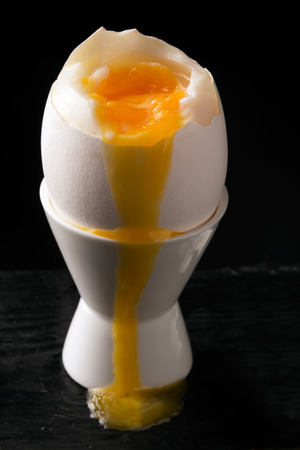 Soft boiled egg on a stand. Dark wooden backgroundの写真素材