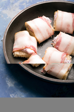 Rich snack of bacon and bread stuffed with cheese and cranberriesの写真素材