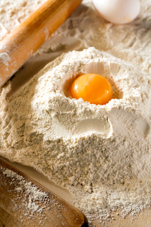Egg and flour on a wooden table (bread ingredients)の写真素材