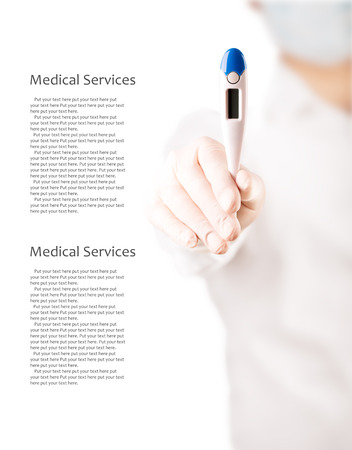 Doctor holds an electronic thermometer for temperature measurement (with copy space)の写真素材
