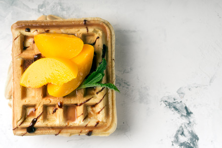 Viennese waffles with peaches and chocolate, decorated with mintの写真素材